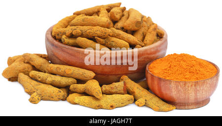 Whole and ground turmeric in wooden bowls over white background Stock Photo