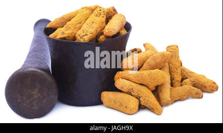 Whole turmeric with mortar and pestle over white background Stock Photo