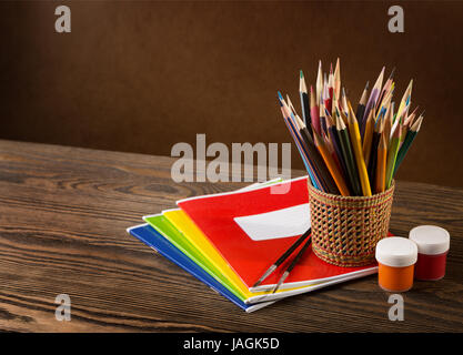 Pencils, paints and brushes on wooden table . Stock Photo