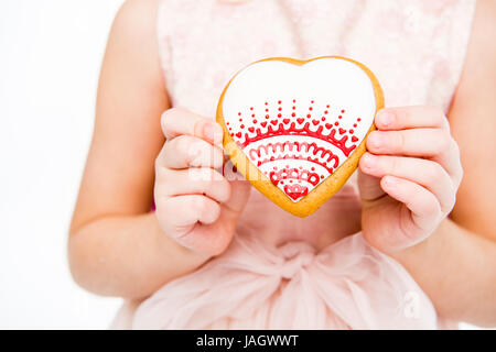 Girl holding heart shaped cookie  Stock Photo