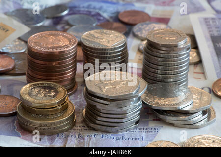 Piles of Great British currency including cash and coins in sterling. Stock Photo