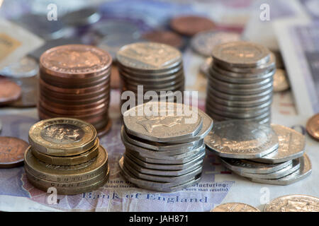 Piles of Great British currency including cash and coins in sterling. Stock Photo