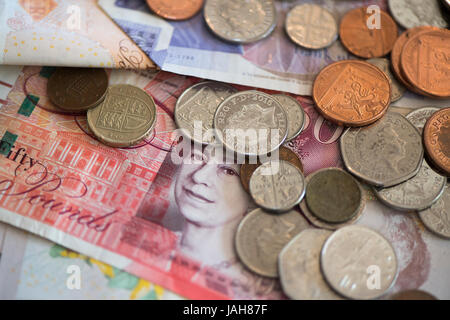 Piles of Great British currency including cash and coins in sterling. Stock Photo