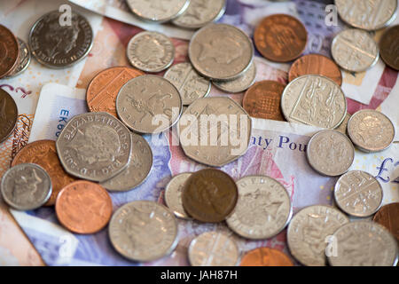 Piles of Great British currency including cash and coins in sterling. Stock Photo