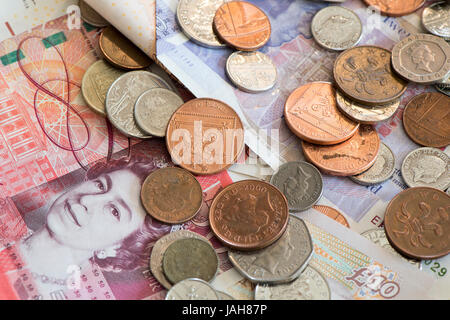 Piles of Great British currency including cash and coins in sterling. Stock Photo