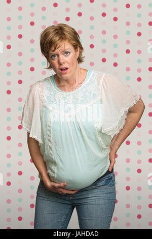 Single pretty young pregnant woman having contractions Stock Photo