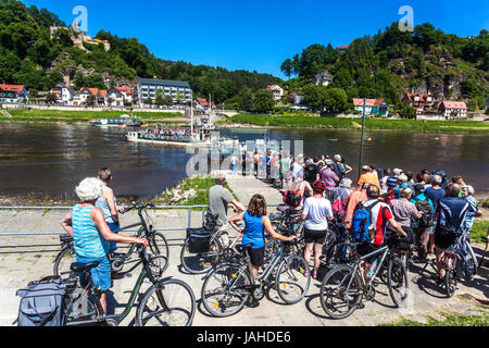 Crowd People on bicycles Cyclists are waiting at the Ferry Boat, Kurort Rathen, Saxon Switzerland summer Saxony, Germany Elbe river bike cycle path Stock Photo