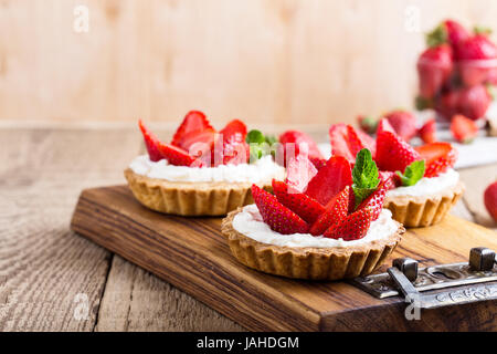 Strawberry shortcake pies on rustic wooden table,  perfect party individual fresh fruit dessert Stock Photo