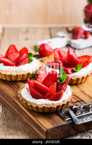 Strawberry shortcake pies on rustic wooden table,  perfect party individual fresh fruit dessert Stock Photo