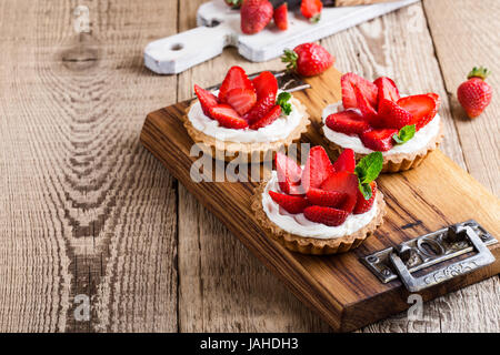 Strawberry shortcake pies on rustic wooden table,  perfect party individual fresh fruit dessert Stock Photo