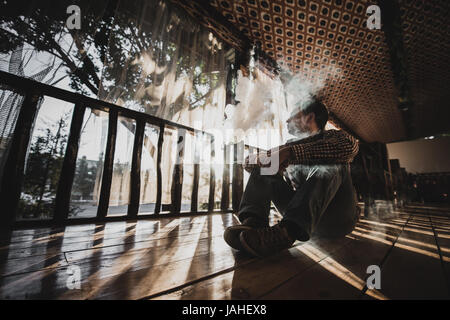 Young Man Using Vapourizer As Smoking Alternative. Stock Photo
