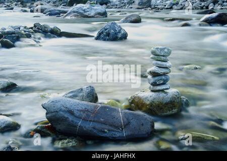 Ein Steinmännchen im Fluss auf einem Stein