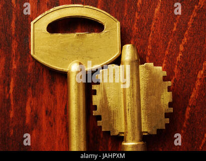 Two keys on a dark wooden background. Stock Photo