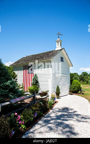 American flag on an old restored white barn with an added cupola, Cape May County, New Jersey, US flag rural America, 2017, pt wooden garden shed Stock Photo