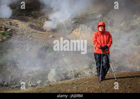 Hiker is standing near boiling springs in Reykjadalur Valley in South Iceland Stock Photo