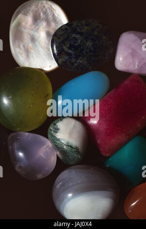 Group of multi-colored semi-precious stones on black close-up Stock Photo