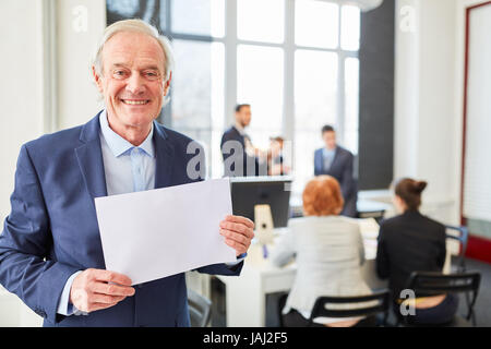 Senior businessman holds blank sign in conference room Stock Photo