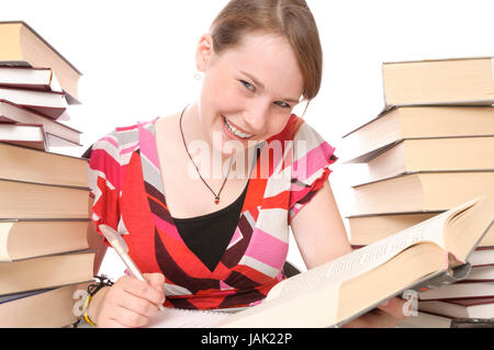 Mädchen, Schülerin beim Lernen, Hausaufgaben machen am Schreibtisch mit Büchern vor weißem Hintergrund. Stock Photo