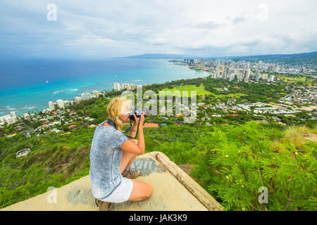 Travel photographer takes a shot of Honolulu and Waikiki beach, Oahu in Hawaii from Diamond Head State Monument. Nature photographer taking pictures o Stock Photo