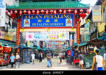 Kuala Lumpur, Malaysia - May 11, 2013: People at Petaling Street in Kuala Lumpur, Malaysia. The street is a long market which specializes in counterfeit clothes, watches and shoes. Famous tourist attraction Stock Photo