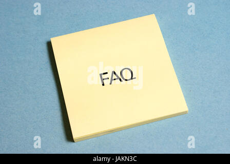 A faq wrote on a yellow sticky pad. Stock Photo