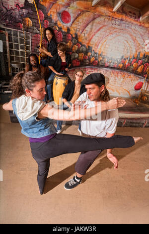 Capoeira instructor teaching woman how to do a roundhouse kick Stock Photo