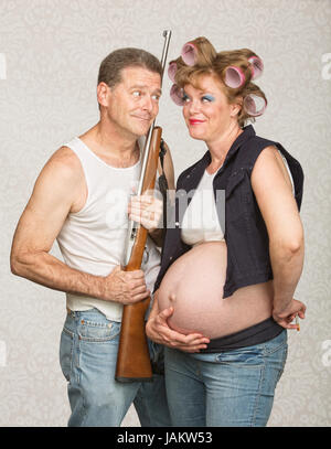 Hillbilly with rifle and adoring pregnant wife Stock Photo