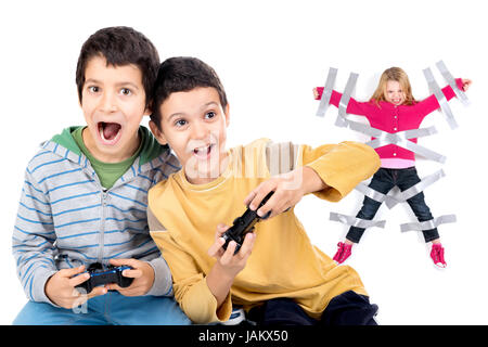 Boys playing video games and young sister glued to the wall with duct tape in the background Stock Photo