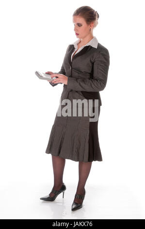 Junge Frau im grauen Business-Anzug und High-Heels schaut entsetzt auf ihren großen Taschenrechner vor weißem Hintergrund Stock Photo