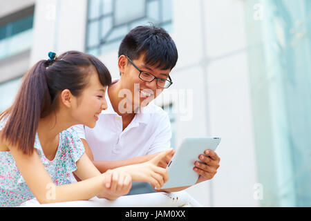 happy young asian or Chinese people using tablet outdoor Stock Photo