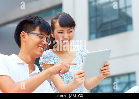 happy young asian or Chinese people using tablet outdoor Stock Photo
