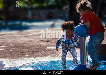 New York, United States  – June 3, 2017: Kids playing and having fun with water in a sunny day of summer in New York City Stock Photo