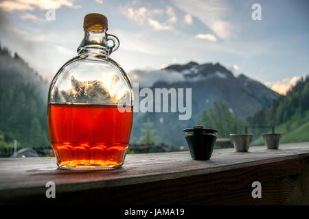 Drinking plum brandy after a long hiking tour in the mountains in Austria during sunset Stock Photo