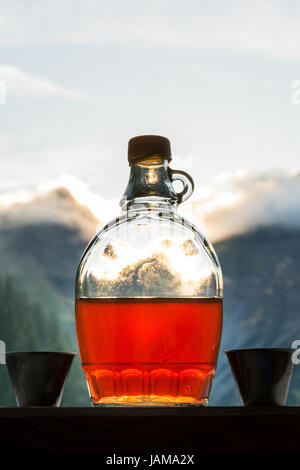 Drinking plum brandy after a long hiking tour in the mountains in Austria during sunset Stock Photo