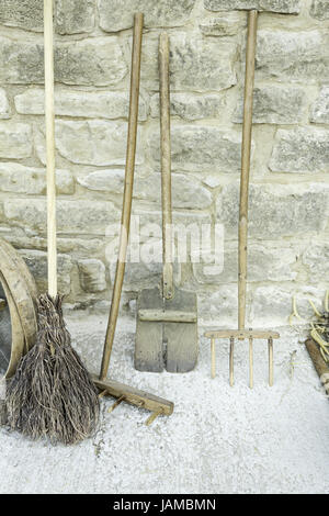 Old farming utensils and wooden objects in street Stock Photo