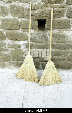 Old straw broom in urban street cleaners Stock Photo