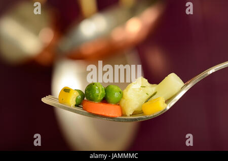 Cooked vegetables on a fork in a kitchen