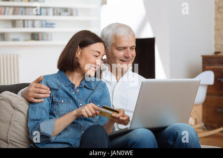 Mature Couple connected with laptop and shopping online Stock Photo