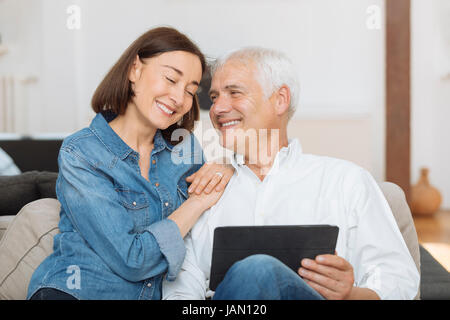 Mature couple at home websurfing with tablet Stock Photo