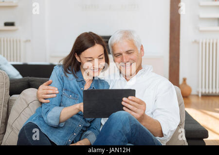 Mature couple at home websurfing with tablet Stock Photo