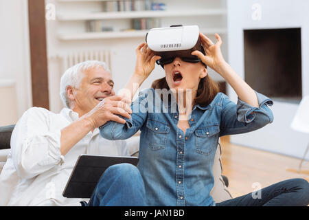 Mature couple using digital tablet and virtual reality headset in living room Stock Photo
