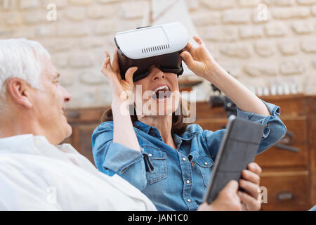 Mature couple using digital tablet and virtual reality headset in living room Stock Photo