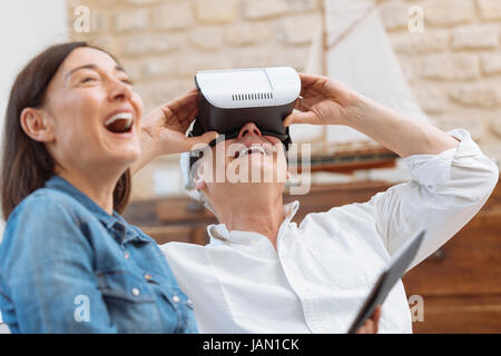 Mature couple using digital tablet and virtual reality headset in living room Stock Photo