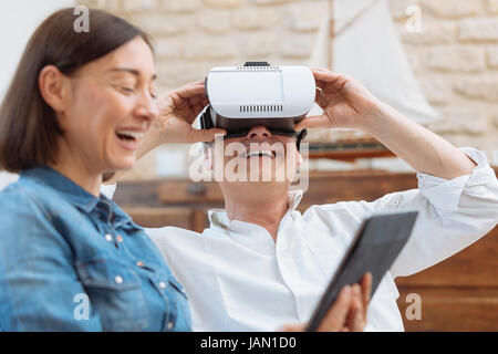 Mature couple using digital tablet and virtual reality headset in living room Stock Photo
