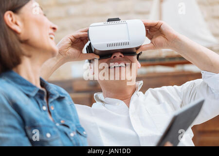 Mature couple using digital tablet and virtual reality headset in living room Stock Photo