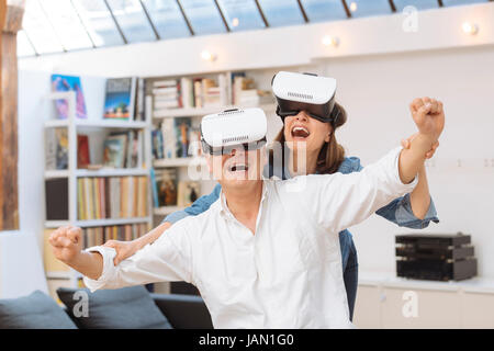 Mature couple using virtual reality headset in living room Stock Photo