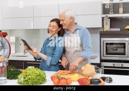 Mature couple cooking meal at home Stock Photo