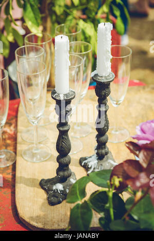 Cast iron candle sticks and champagne gasses. Garden party concept. Stock Photo