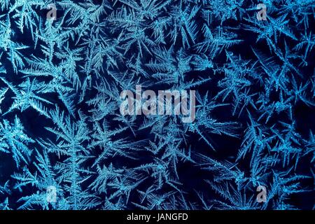 Frost formations on a window with dark background Stock Photo