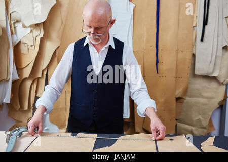Experienced Tailor Working on Garments in Atelier Stock Photo